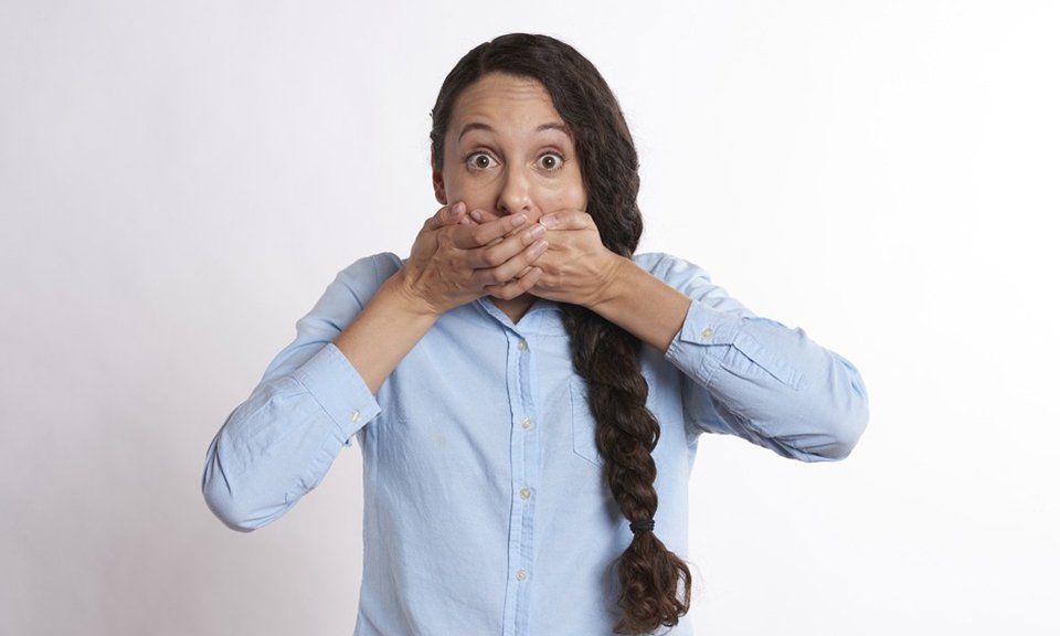 Surprised woman covering her mouth with both hands