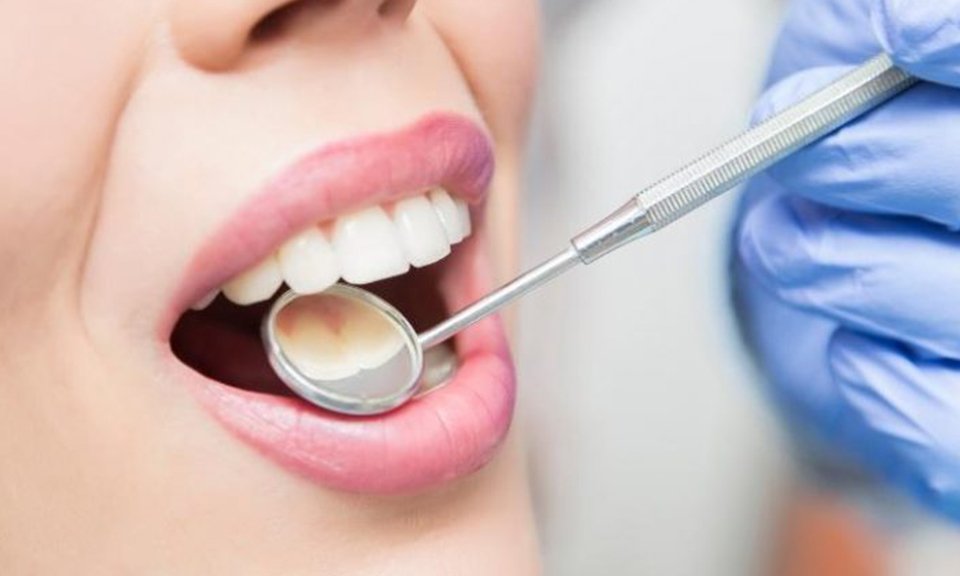 Dentist examining a patient's teeth with a dental mirror